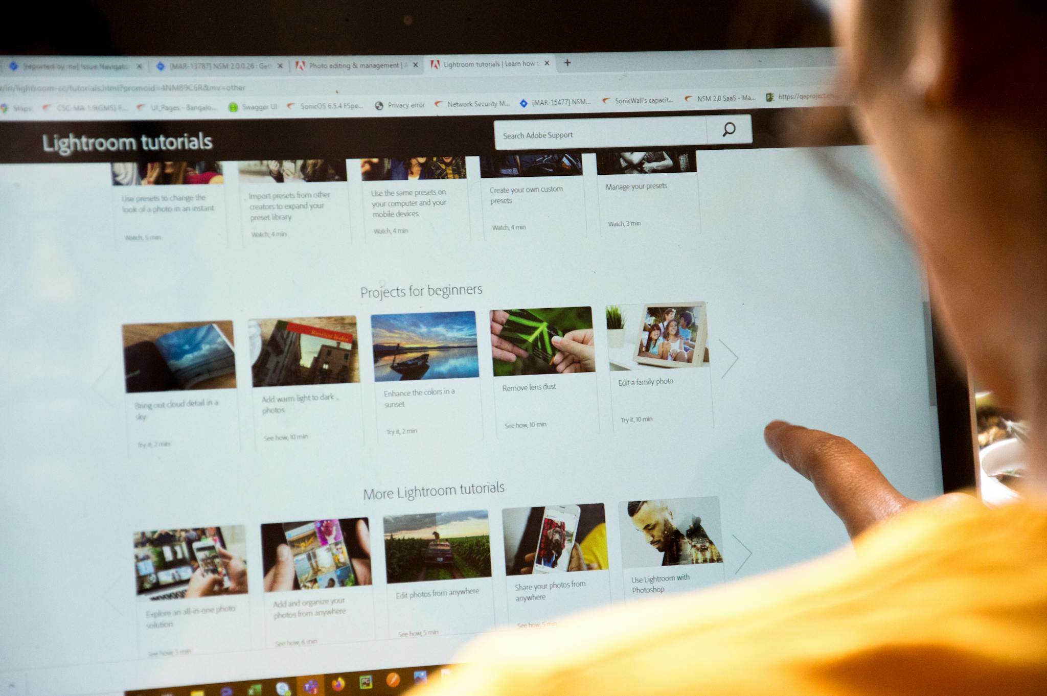 Woman Exploring Lightroom Tutorials On Computer Screen